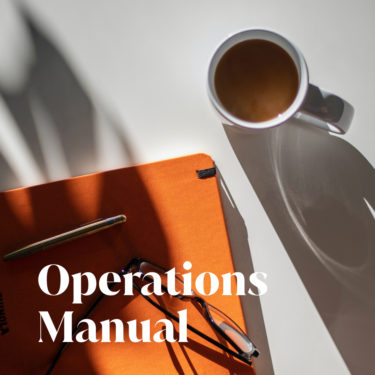 An orange notebook, glasses, and a cup of coffee sit on a white table with Operations Manual text overlay.