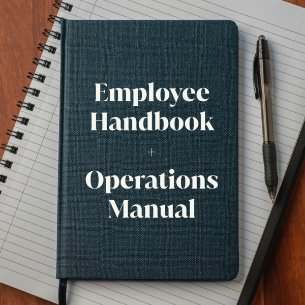Employee Handbook + Operations Manual text over an image of a two notebooks and a pen on a wooden table.